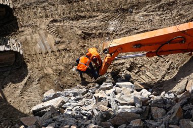 Manhattan 'ın merkezindeki Manhattan, New York' ta yeni bir binanın inşaatı başlarken Manhattan 'ın ana kayalarını yıkmak için kullanılan makineleri inceleyen işçiler.