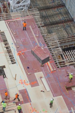 New York, New York: Manhattan, New York 'ta 42 katlı yüksek katlı bir apartman inşaatı için kontrplak çarşaflarına rehberlik eden işçilerin hava manzarası.