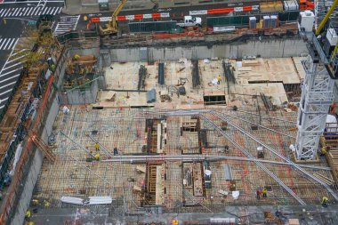 New York, New York: İşçiler, yağmurun Manhattan, New York 'ta 42 katlı yeni bir apartman binasının inşaatına gölge düşürmesinden sonra görevlerine devam ediyorlar.