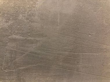 Gri çimento arka plan duvarının çimento alçısından yapılmış bir deseni var..