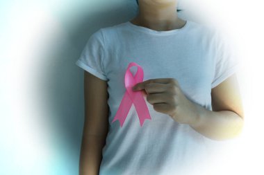 Pembe kurdele takan klasik bir kadın. Göğüs kanseri farkındalığı. Sağlık hizmetleri ve pembe arka planda izole edilmiş tıbbi konsept..