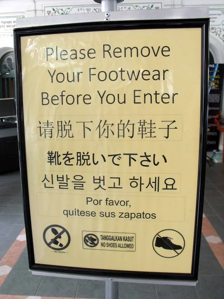 シンガポール 2016年3月8日 モスクのドアに掲示された看板は 私たちが靴を脱ぐために異なる言語で呼び出します ストック写真