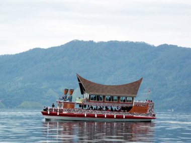 Pulau Samosir, Toba Gölü, Sumatra, Endonezya, 11 Ocak 2018: Arka planda dağ ile birlikte Toba Gölü 'nü geçen tipik bir feribot. Endonezya