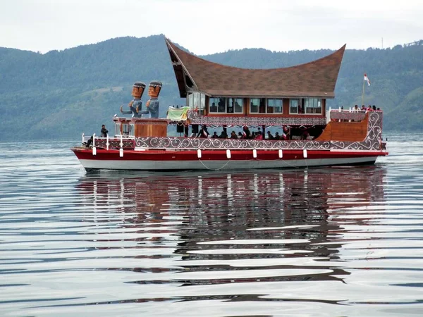 Pulau Samosir, Toba Gölü, Sumatra, Endonezya, 11 Ocak 2018: Toba Gölü 'nü geçen feribotlardan birinin sudaki yansıması bölgenin tipik dekorasyonuyla. Endonezya