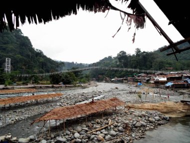 Endonezya 'nın kuzeyindeki Bukit Lawang' da Bahorok Nehri 'nin ortasında kulübeler..