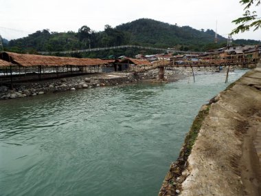 Bahorok Nehri Bukit Lawang 'dan geçerken Kuzey Sumatra Eyaleti' nin arka planında dağ bulunur..