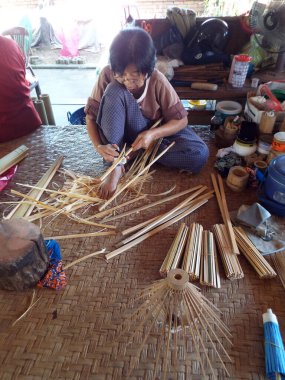 Bor Sang, Chiang Mai, Tayland, 22 Aralık 2018: Bor Sang Şemsiye Yapım Merkezi 'nde şemsiye yapmak için bambu kesen usta kadın. El yapımı şemsiye fabrikası..