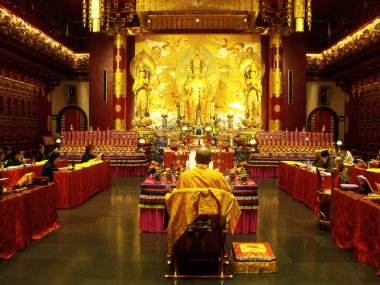 Singapur, 7 Mart 2016: Budist bir keşiş Buda Dişi Kalıntısı Tapınağı 'nın ana salonunda birden fazla ibadethanenin önünde bir tören düzenledi. Singapur