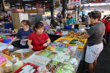 Georgetown, Penang, Malezya, 4 Ocak 2020: İki tezgahtar Georgetown, Malezya 'daki Pasar Lebuh Cecil Market' te bir müşteriye hizmet veriyor.