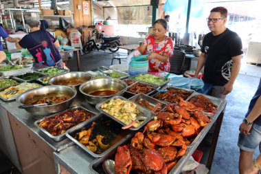 Georgetown, Penang, Malezya, 4 Ocak 2020: Bir kadın Georgetown, Malezya 'daki Pasar Lebuh Cecil Pazarı' nda bekleyen müşteriler için bulaşıkları yıkadı.