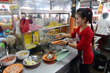 Georgetown, Penang, Malezya, 4 Ocak 2020: Bir kadın Georgetown, Malezya 'daki Pasar Lebuh Cecil Market' te bir tabak erişte hazırlıyor.