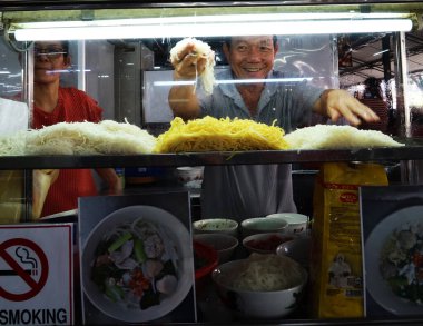 Georgetown, Penang, Malezya, 4 Ocak 2020: Gülümseyen bir adam Georgetown, Malezya 'daki Pasar Lebuh Cecil Market' te eriştesini sergiliyor.