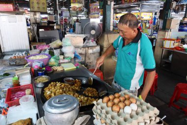 Georgetown, Penang, Malezya, 4 Ocak 2020: Georgetown, Malezya 'daki Pasar Lebuh Cecil pazarında yemek pişiren bir adam.