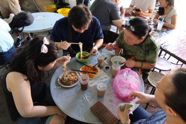 Georgetown, Penang, Malezya, 4 Ocak 2020: Georgetown, Malezya 'daki Pasar Lebuh Cecil Pazarı' nda bir aile yemek yiyor.
