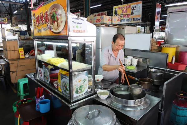 Georgetown, Penang, Malezya, 4 Ocak 2020: Bir adam Georgetown, Malezya 'daki Pasar Lebuh Cecil Market' teki tezgahında erişte hazırlıyor.