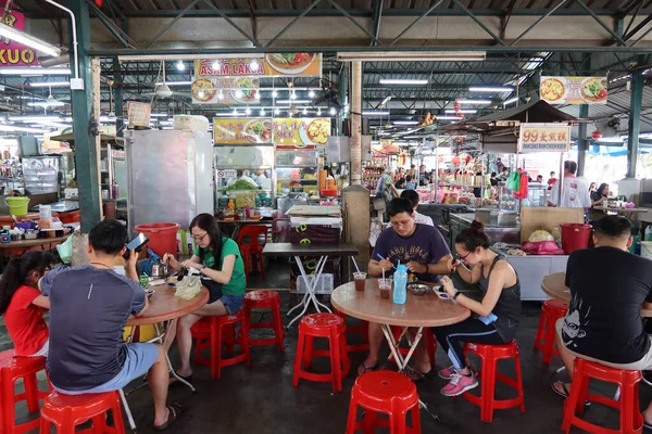 Georgetown, Penang, Malezya, 4 Ocak 2020: İnsanlar Georgetown, Malezya 'daki Pasar Lebuh Cecil Market' in masalarında yemek yiyorlar.
