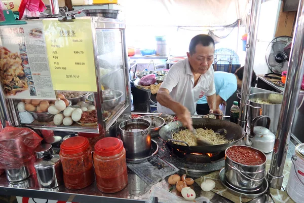 Georgetown, Penang, Malezya, 4 Ocak 2020: Bir adam Georgetown, Malezya 'daki Pasar Lebuh Cecil Market' teki tezgahında erişte pişiriyor.