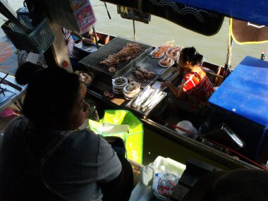 Amphawa, Tayland, 23 Ocak 2016: İskelede garson ve teknesindeki aşçı müşterilerin Amphawa Denizcilik Pazarı 'na gelmesini bekliyor