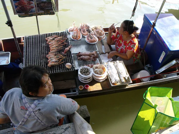 2016年1月23日 泰国爱荷华市 一名妇女在船上烹调烧烤海鲜 而女服务员则在爱荷华市的浮动市场等待下订单 — 图库照片