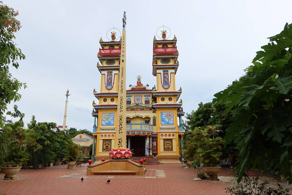 Hoi An, Vietnam, September 20, 2020: Main facade with a monolith in the courtyard of the Cao Dai Taoist temple. Hoi An, Vietnam