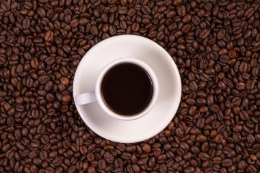 Kahve çekirdeği arkaplanda bir fincan kahve. Üst görünüm