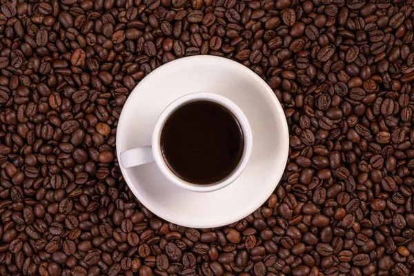 Kahve çekirdeği arkaplanda bir fincan kahve. Üst görünüm