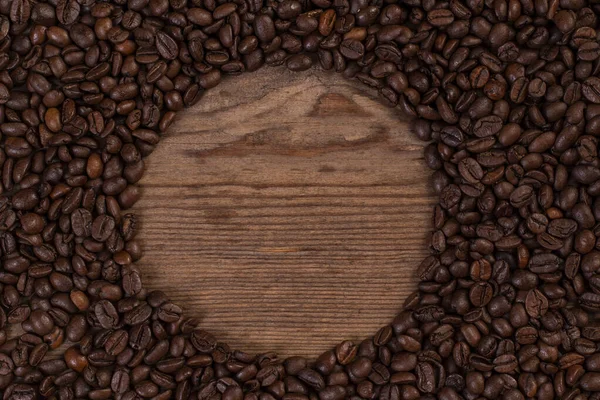Kahve çekirdekleri ahşap arka planda izole edilmiş ve metin için kopyalama alanı var. Üst görünüm.