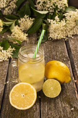 Ev yapımı Elderflower limonata, limon dilimi ve ahşap arka planda nane..
