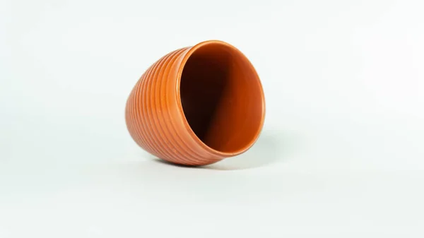 Seramik cila kaplı çay kulhad, Hint geleneklerinde sıcak çay sunan kil bardağı beyaz arka planda tutar. Çayla kil karışımının tatlılığı çok tatlı bir çay tadı..