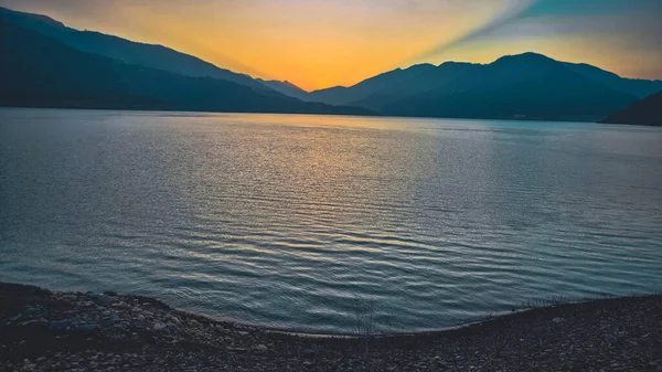 Beautiful sunset view at Tehri Lake in Uttarakhand, India, with golden and blue hues reflecting on calm water and mountains in the background. Perfect for travel, tourism, nature, landscape, peace, and adventure concepts.