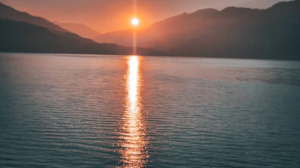 Scenic sunrise view over Tehri Lake in Uttarakhand, India, with golden sunlight reflecting on calm water and mountains in the background. Perfect for travel, tourism, nature, peace, and adventure themes.