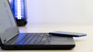 Akıllı telefon ve bulanık arkaplan ile ahşap masadaki dizüstü bilgisayar