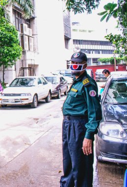 Coronavirüs salgını. Dhaka, Bangladeş - 09 Temmuz 2020: Güvenlik Bölgesi 'ne girmeden önce sıcaklığı kontrol eden güvenlik personeli. Güvenlik prosedürleri.