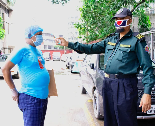 Coronavirus epidemic. Dhaka, Bangladesh - July 09 2020: Security personnel checking temperature before entering the Safety Area. Security procedures.