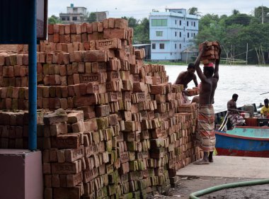 Nehir kenarına tuğla döşeyen inşaat işçisi, fotoğraf 25 Eylül 2020 'de Shitolokkha Nehri, Narayanganj, Rupgonj' dan çekildi..