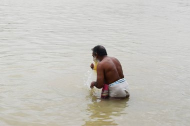 Bir adam nehir suyunda abdest alıyor, fotoğraf 28 Eylül 2020 'de Shitolokkha Nehri, Narayanganj, Rupgonj' dan çekildi..