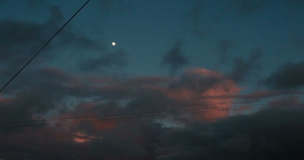 Pilvinen taivas kaupunkimaiseman yläpuolella illalla auringonlaskun aikana — kuvapankkivideo