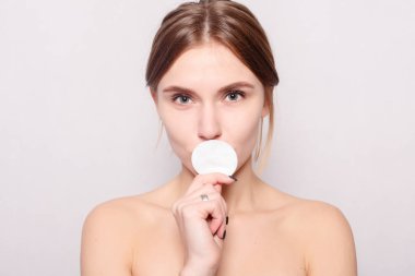 Pamuk yastık kullanan kadın. Pamuk tarafından cilt temizleme mutlu gülümseyen güzel ve genç birbayan. açık renkli. Gülümseyen güzel kadın. Mükemmel taze cilt. Gençlik ve cilt bakım kavramı