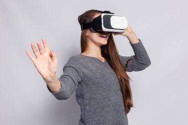 teknoloji, sanal gerçeklik, eğlence ve insanlar kavramı - sanal gerçeklik kulaklık veya 3d gözlük ile mutlu bir genç kadın. Sanal gerçeklik gözlükleri olan kadın. Atış, arka planı gri studio