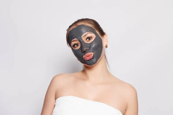 Woman Face Mask. Portrait Of Beautiful Girl Removing Cosmetic Black Peeling Mask From Facial Skin. Closeup Of Attractive Young Woman With Natural Makeup And Cosmetic Peel Mask On Face. High Resolution