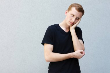 Moda, stil, duygular ve insanlar kavramı - Kızıl çilli bir gri ile güzel bir erkekçe adamın portresi yakından arka plan siyah T-shirt. El olması ile kafa yorgun holding