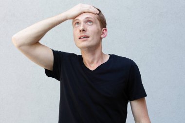 Moda, stil, duygular ve insanlar kavramı - Kızıl çilli bir gri ile güzel bir erkekçe adamın portresi yakından arka plan siyah T-shirt. Onun yüzünü, çatık adam ellerini kafasına koyarak