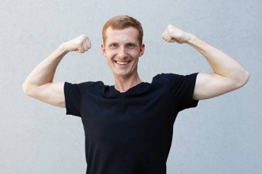 Moda, stil, duygular ve insanlar kavramı - Kızıl çilli bir gri ile güzel bir erkekçe adamın portresi yakından arka plan siyah T-shirt. onun pazı ve bir gülümseme gösterir