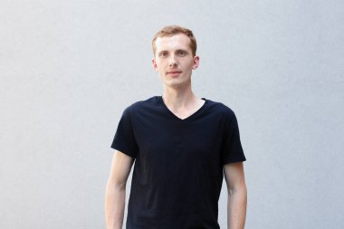 Moda, stil, duygular ve insanlar kavramı - Kızıl çilli bir gri ile güzel bir erkekçe adamın portresi yakından arka plan siyah T-shirt. Kamera ve gülümsüyor görünüyor