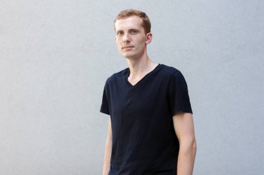 Moda, stil, duygular ve insanlar kavramı - Kızıl çilli bir gri ile güzel bir erkekçe adamın portresi yakından arka plan siyah T-shirt. Kamera ve gülümsüyor görünüyor