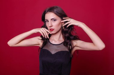 Moda, stil ve insanlar kavramı - zarif siyah kokteyl elbisesi güzel genç kadın çeneme elini tutarak, uzağa arıyorsunuz ve düşünüyor. Üç çeyrek uzunluğu stüdyo, pembe arka plan vurdu..