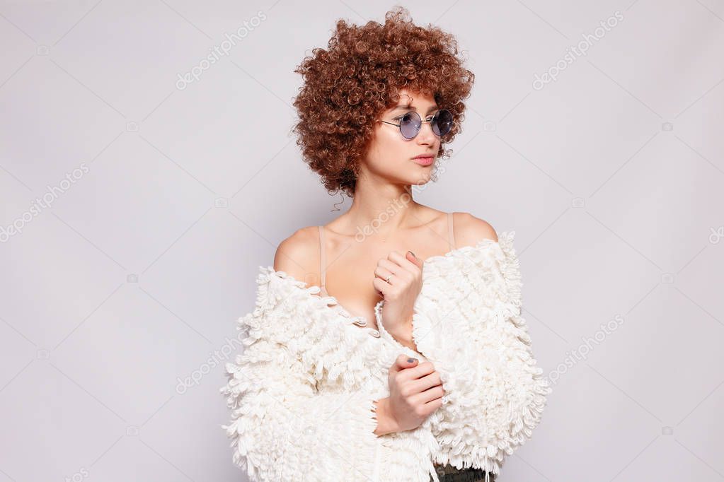 Portrait of smiling young black woman. Portrait of a beautiful young woman with African American afro haircut and glamor makeup. Studio shot. Attractive girl wearing eyeglasses.