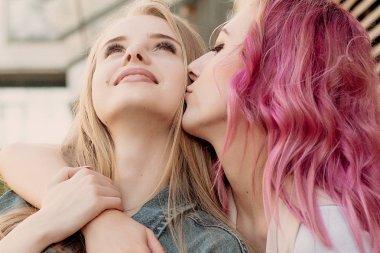 Şehirde takılmak süre kucaklayan hipster Genç Yetişkin arkadaşlar. İki genç kadın gülüyor ve kaygısız tatil yaşam tarzı zevk yürüyüş