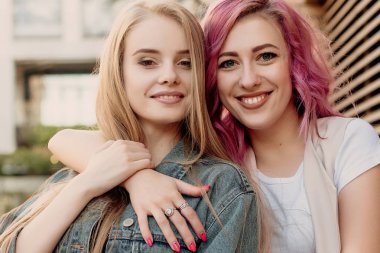 Şehirde takılmak süre kucaklayan hipster Genç Yetişkin arkadaşlar. İki genç kadın gülüyor ve kaygısız tatil yaşam tarzı zevk yürüyüş