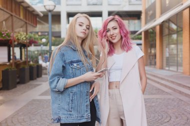 Şehirde takılmak süre kucaklayan hipster Genç Yetişkin arkadaşlar. İki genç kadın gülüyor ve kaygısız tatil yaşam tarzı zevk yürüyüş